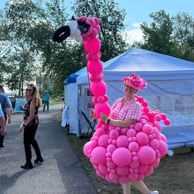 Flamingo balloon-dress performer at a festival