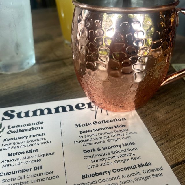 Copper mule mug beside a summer cocktail menu