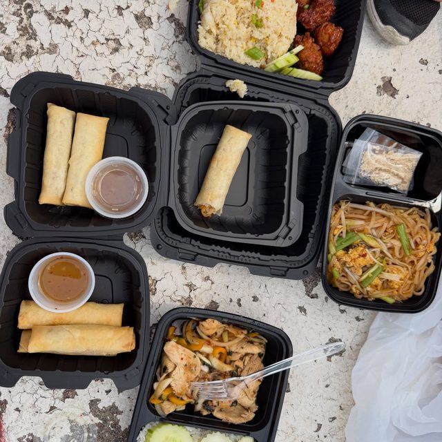 Thai takeout spread of spring rolls, fried rice and noodles