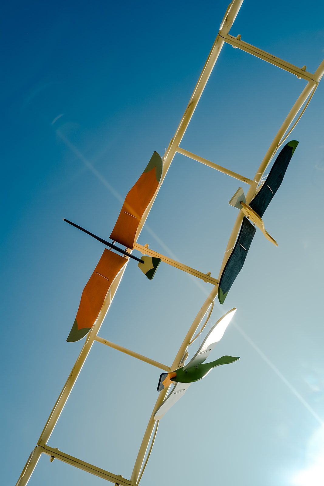 Wooden bird gliders soaring against a bright blue sky