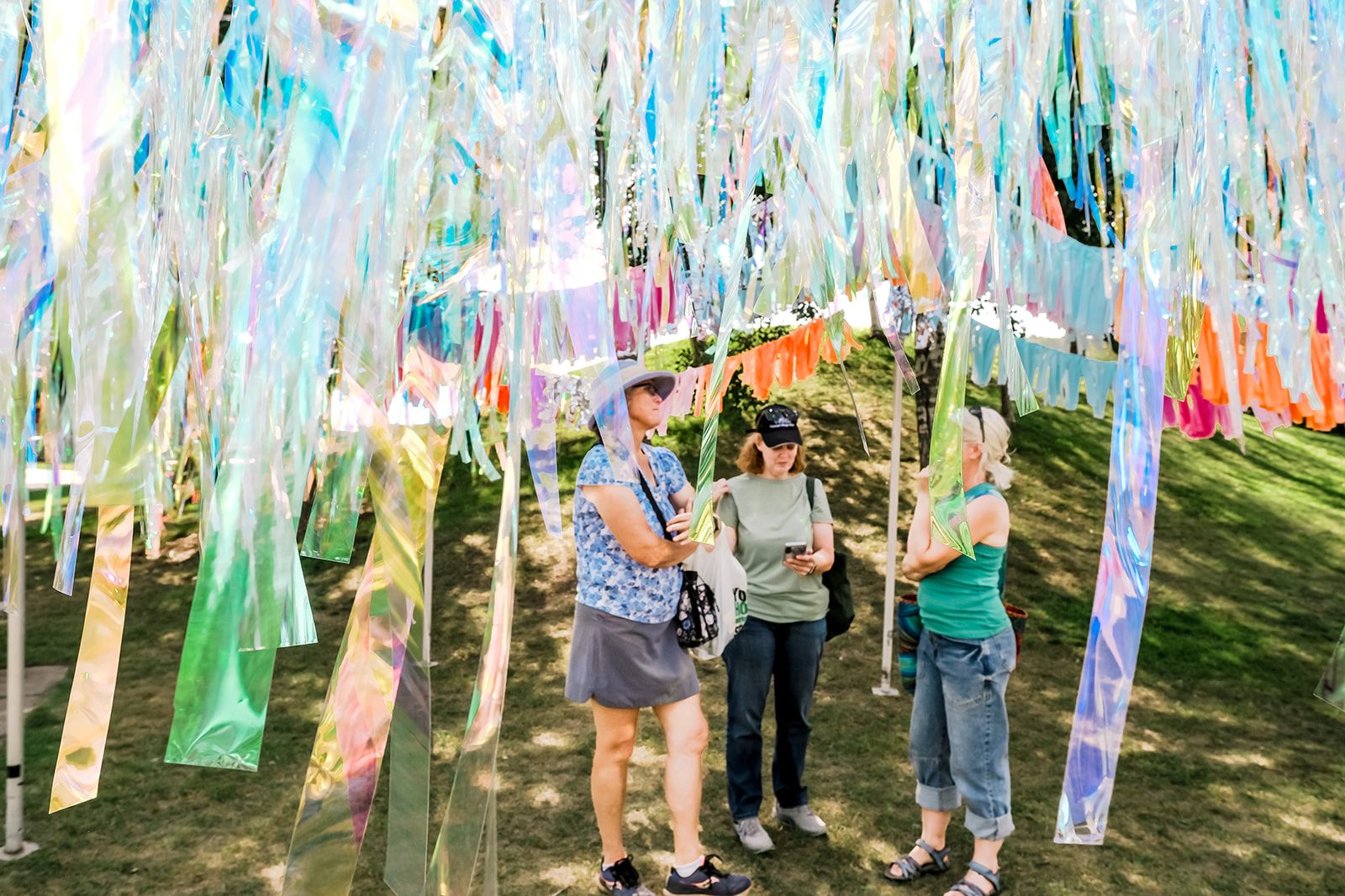 Festivalgoers beneath a canopy of iridescent streamers
